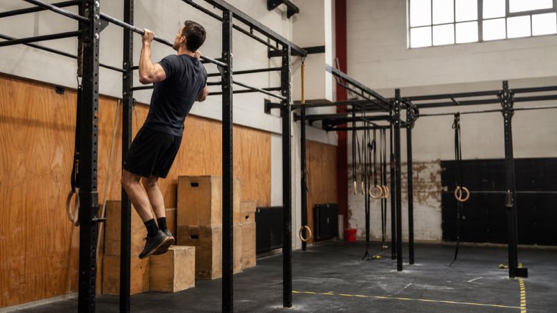 Athlete training on a pull-up rig in a functional fitness gym
